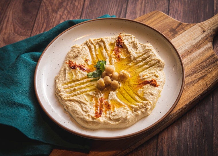 Plate of hummus on a cutting board - can cats eat hummus?
