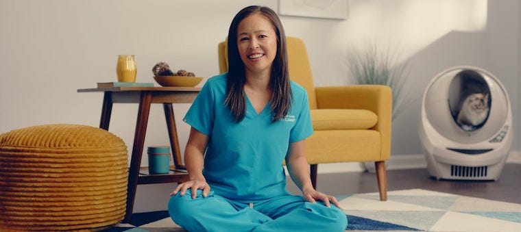 Dr Justine Lee sitting near a Litter-Robot with cat