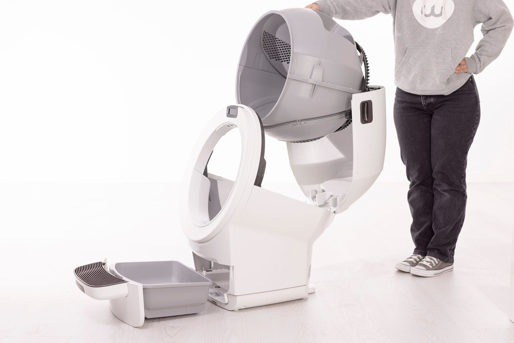 Litter-Robot 5 globe removed and held above the unit with the bonnet open and drawer removed