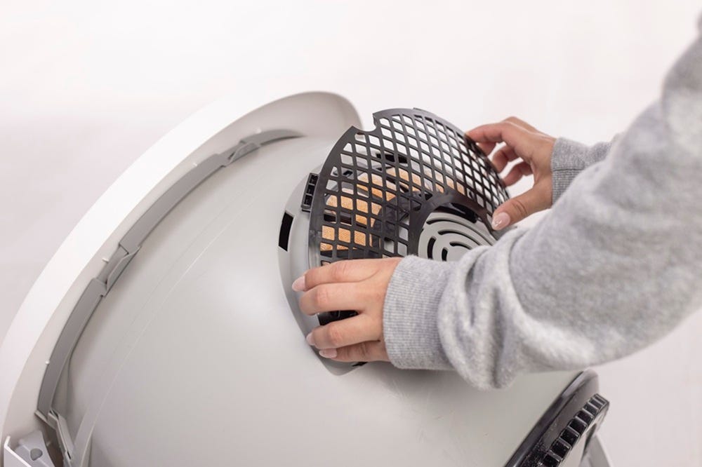 Inserting bottom two tabs of filter cover in globe with OdorTrap Holder installed