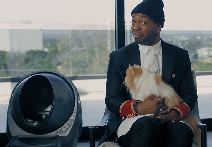 Todrick Hall smiling while holding a cat