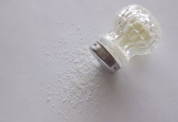 table salt spilled on white background