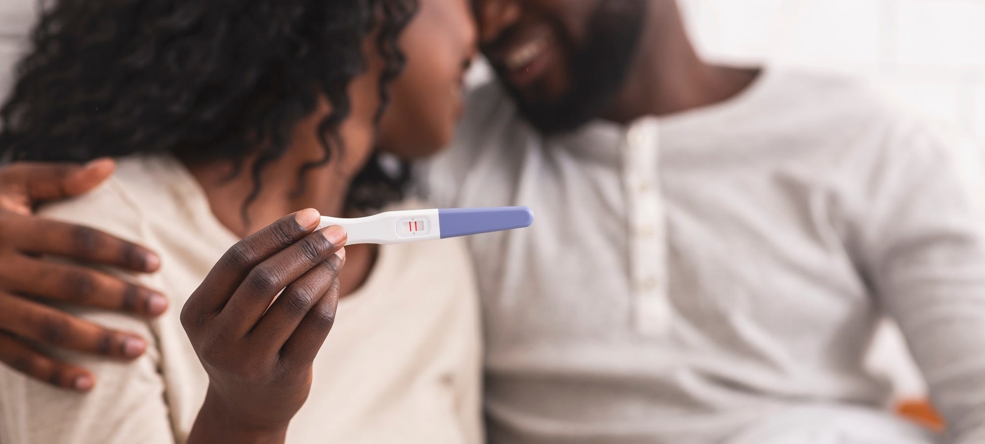 happy man and woman holding positive pregnancy test