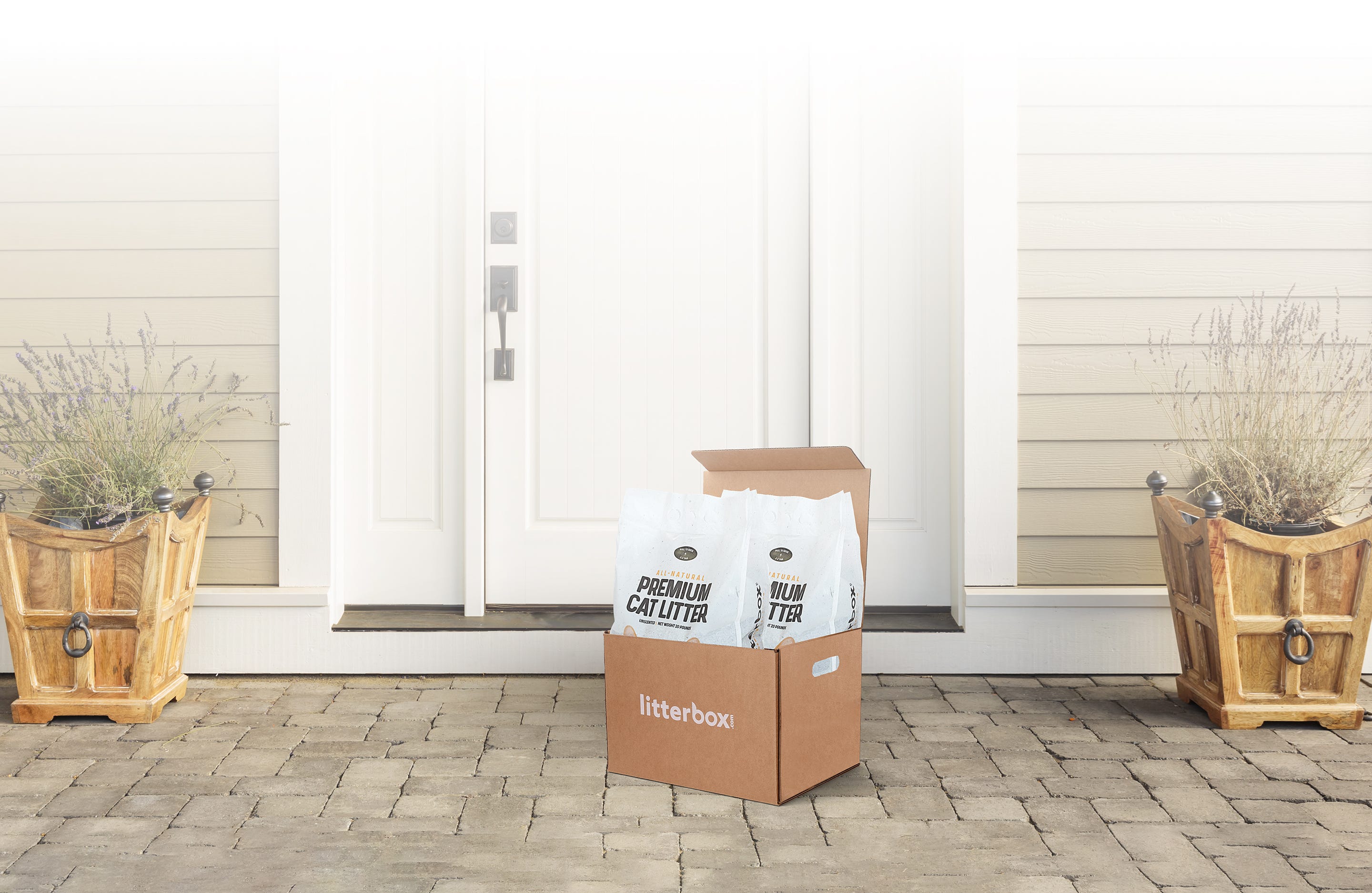 A box of premium litter delivered at a door.