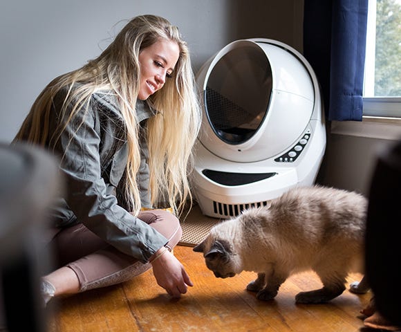 Woman playing with cat in front of Litter-Robot